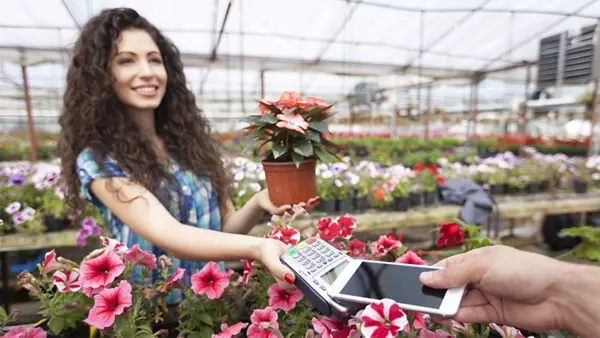 A person purchases a plant at a gardening retail store